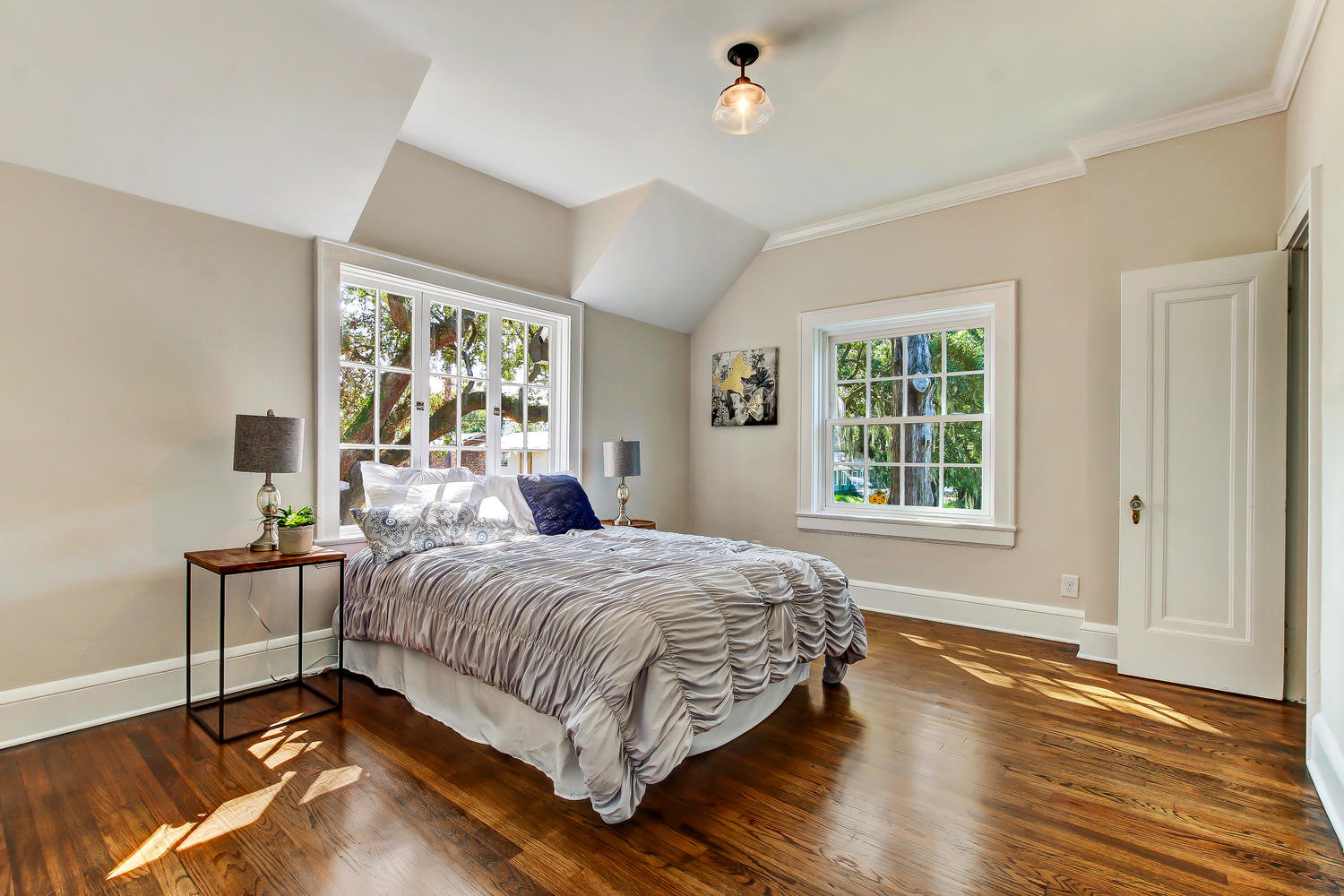 Spacious guestroom with hardwood floors and natural light